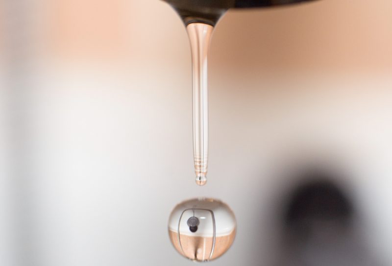 drop of water from faucet in bathroom with reflection