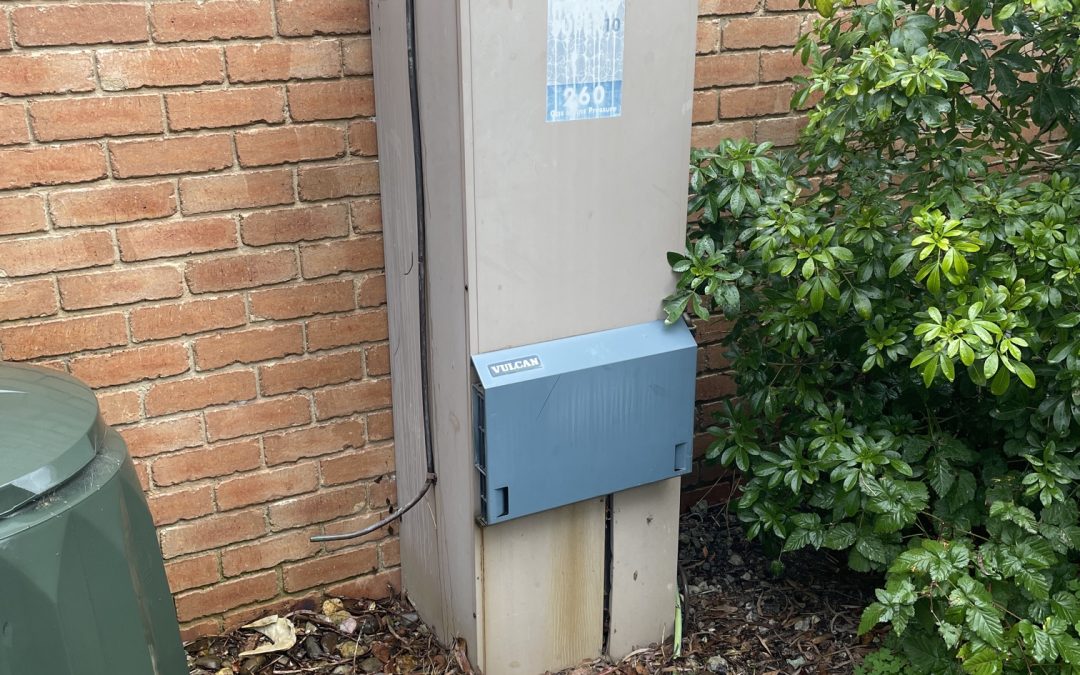 Old gas hot water system outside a Melbourne home showing an ageing hot water unit